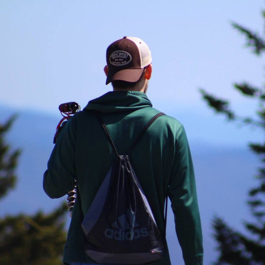 Caleb Eckman walking on top of a mountain